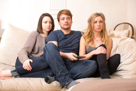 Fascinated teenagers sitting watching television