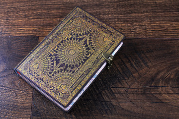 Old ornate notebook on wood background