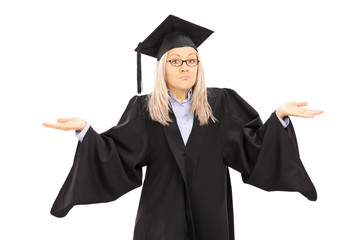 Confused young female in graduation gown