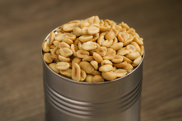 salted peanuts, nuts in a small metal bowl with wood background