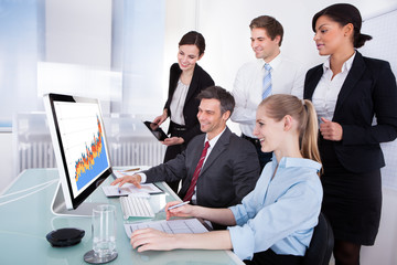 Businesspeople Looking At Graph On Computer
