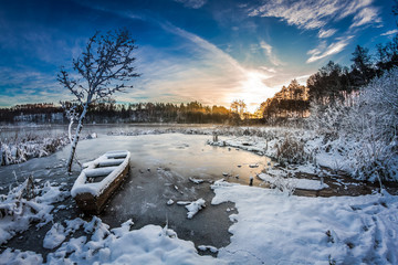 Sunrise on winter lake covered with snow