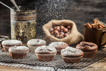 Falling icing sugar on fresh chocolate muffins