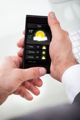 Businessman Looking Weather Forecast On Cellphone