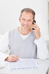 Man In Front Of Newspaper Talking On Cellphone