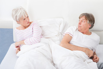 Angry Couple Lying On Bed
