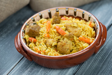 Uzbek traditional pilaf in a ceramic plate, horizontal shot