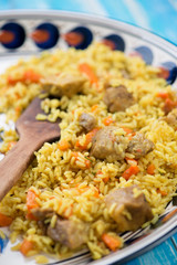 Uzbek traditional pilaf in a plate with national ornaments