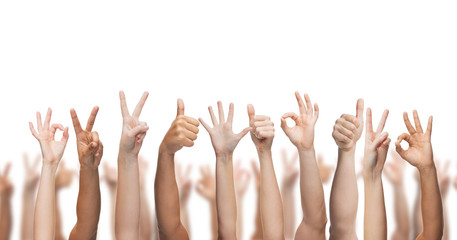 human hands showing thumbs up, ok and peace signs