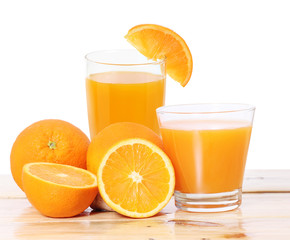 Orange juice and slices on wood