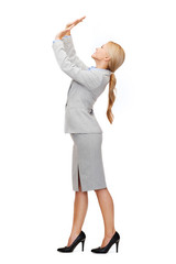 businesswoman pushing up something imaginary