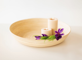 candles and iris flowers in wooden bowel