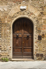 Fototapeta na wymiar Zamknięte drzwi budynku w średniowiecznym mieście San Gimignano