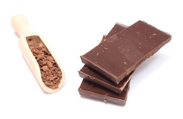 Stack of dark chocolate and grated on wooden spoon