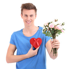 Portrait of handsome young man with flowers and gift, isolated
