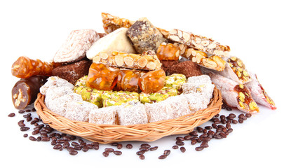 Tasty oriental sweets on wicker tray, isolated on white