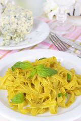 Delicious pasta with pesto on plate on table on light