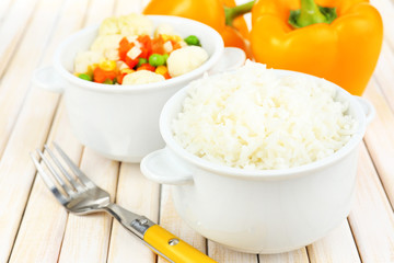 Cooked rice with vegetables on wooden table close up