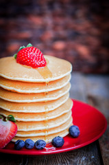 Tasty homemade pancakes with strawberries,blueberries and maple
