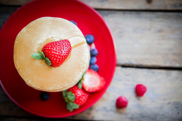 Tasty homemade pancakes with strawberries,blueberries and maple