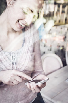 Smiling young woman using smartphone