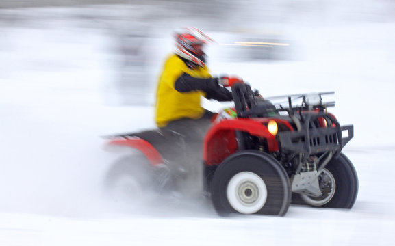 Quad bike driver rides over snow track