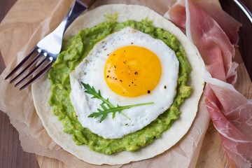 Breakfast with fried egg and sauce of avocado on grilled flour