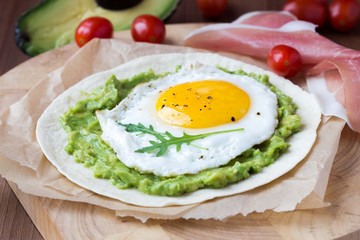 Breakfast with fried egg and sauce of avocado on grilled flour