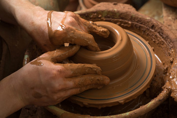 hands of a potter, creating an earthen jar