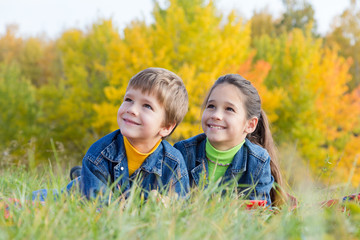 Two smiling kids on the autumn meadow