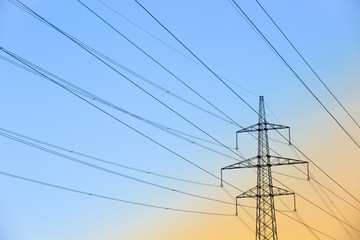 Electric power lines against blue and yellow sky