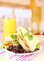 Fresh and tasty sandwiches on plate on table on light