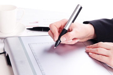 Female hand using graphics tablet on table close up