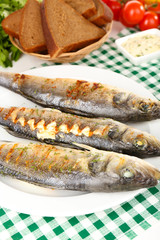 Delicious grilled fish on plate on table close-up