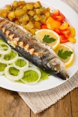 Delicious grilled fish on plate on table close-up