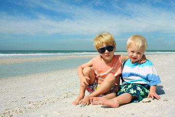 Two Young Children Sitting on Beautiful Beach