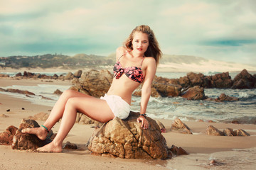A beautiful blonde lady in her bikini on a beach in Africa