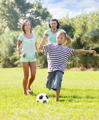 Naklejka premium teenage boy with parents playing in soccer
