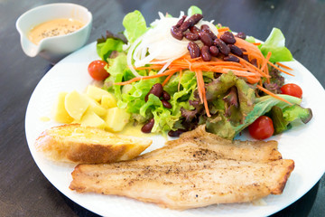 Fish steak with salad, dipping sauce and garlic bread