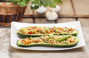 Zucchini stuffed with couscous vegetable salad on wooden table