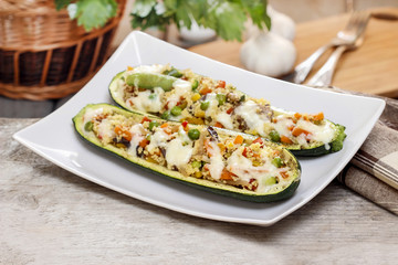 Zucchini stuffed with couscous vegetable salad on wooden table