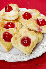 Puff pastry cookies in heart shape filled with cherries