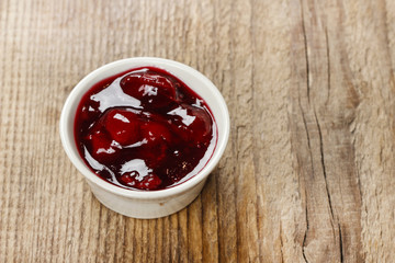 Bowl of marmalade on wooden table