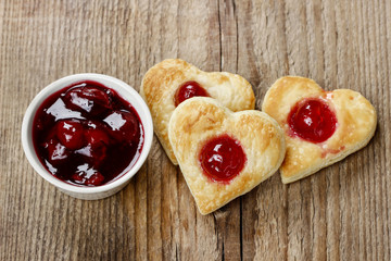 Puff pastry cookies in heart shape filled with cherries