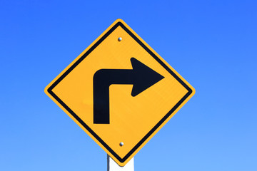 turn right yellow road sign on blue sky background