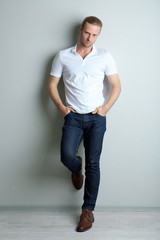 Fashion young model poses over wall with shadow