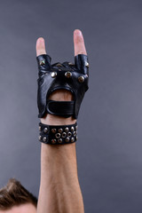 Hand of rocker in leather bracelet and mitten,
