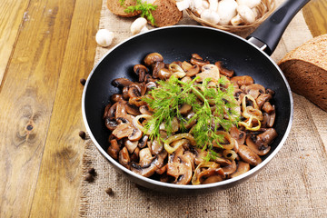 Delicious fried mushrooms in pan on table close-up