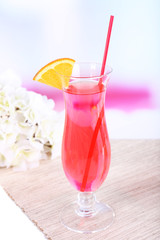 Glass of cocktail on table on light background