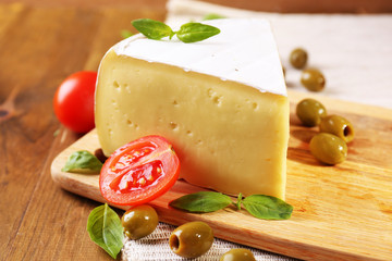Tasty Camembert cheese with tomatoes, olives and basil,